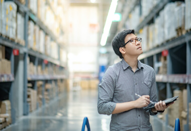 an Asian male is checking goods in the warehouse