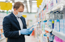 a male in the supermarket wearing a single-use face mask