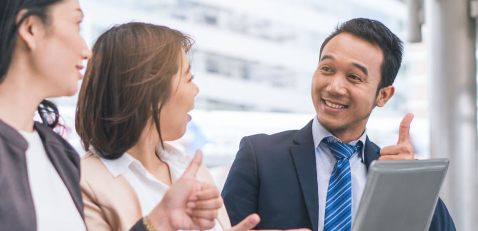 one male staff is having a conversation with 2 female in the business scenario