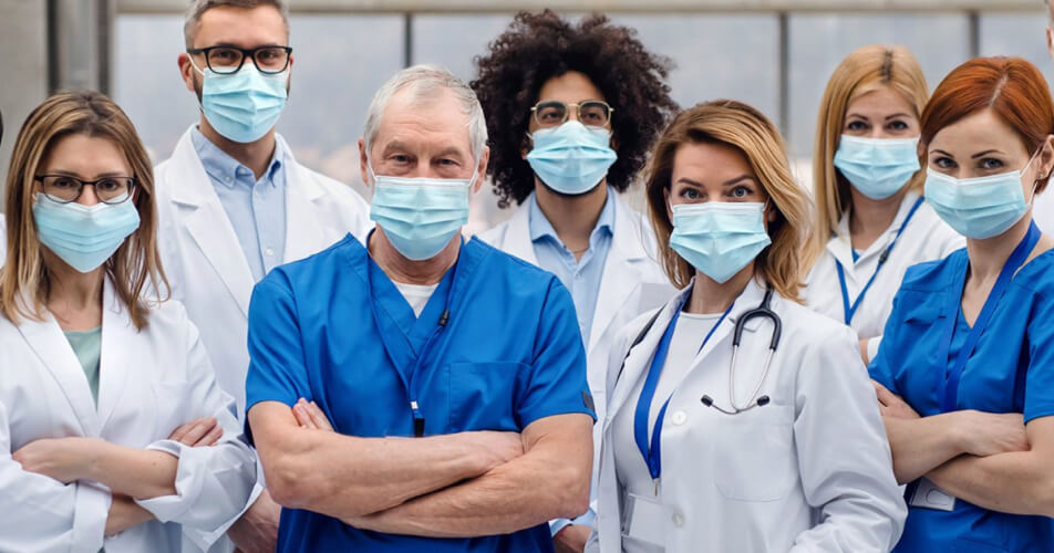 a team of doctors and nurses wearing surgical masks and protective overalls